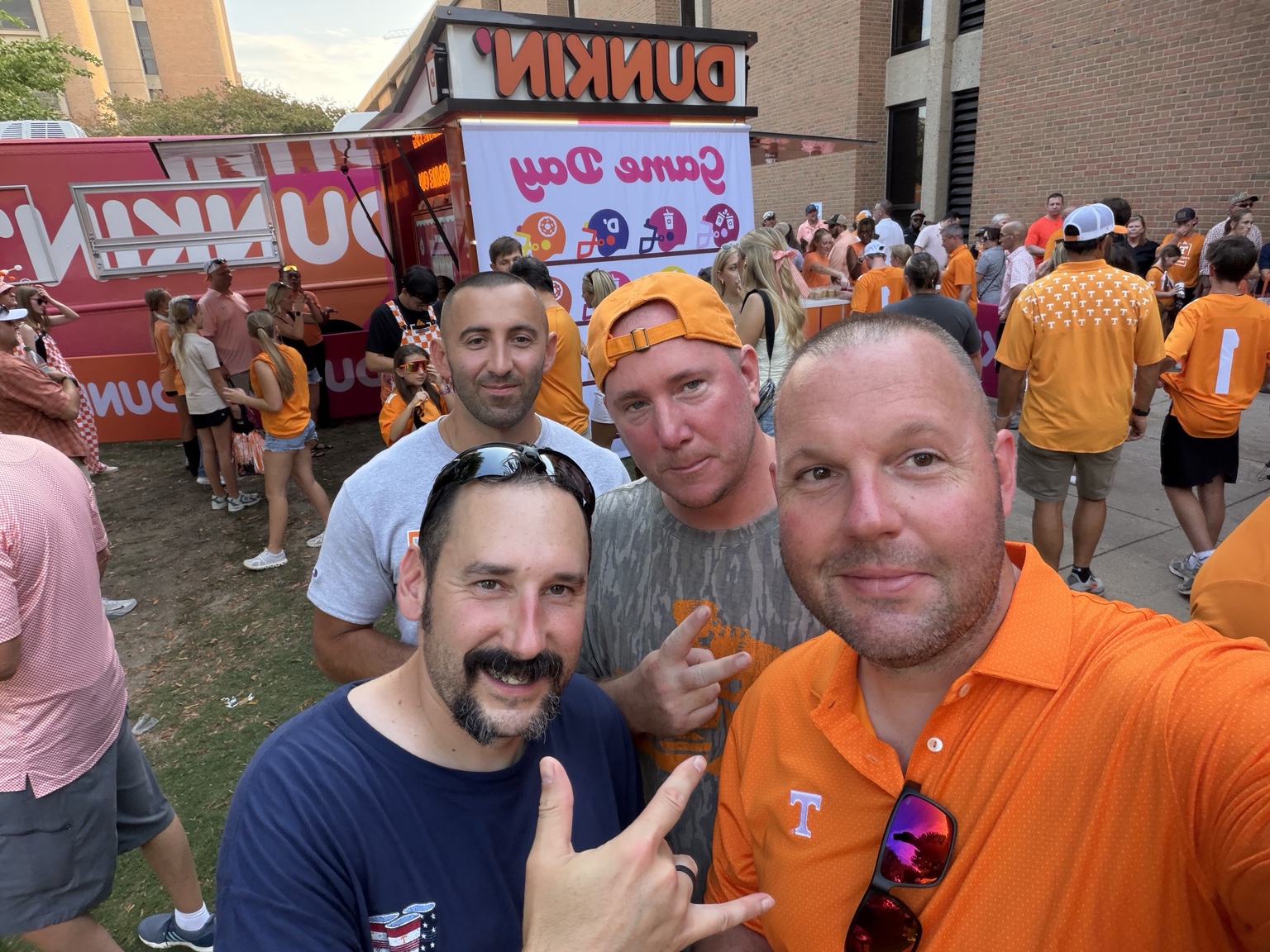 Four friends taking a group selfie among Tennessee football fans before the game